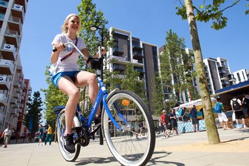 Moradora da Vila pedala em frente aos prédios que alojaram milhares de atletas olímpicos em 2012 / Foto: Getty Images